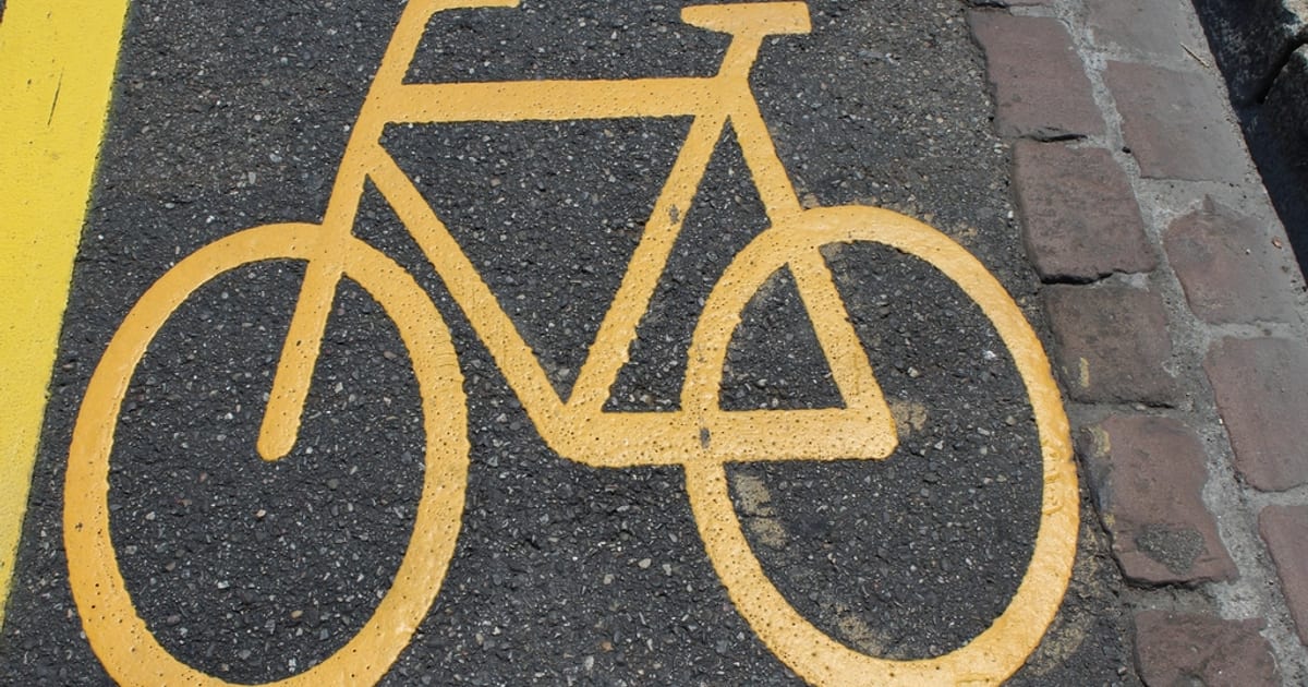 A yellow bicycle symbol painted on a bike lane